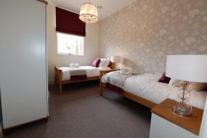 a bedroom with two beds and a window at Hunter House Apartment FREE PARKING ONSITE in York