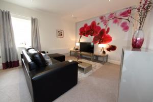 a living room with a black couch and a tv at Hunter House Apartment FREE PARKING ONSITE in York