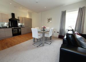 a living room with a table and white chairs at Hunter House Apartment FREE PARKING ONSITE in York