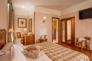 a bedroom with a large bed with a television on the wall at Albergo Ottocento in Rome