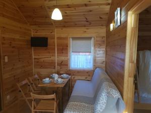a room with a bed and a table in a log cabin at Domki Letniskowe Poranek in Jezierzany