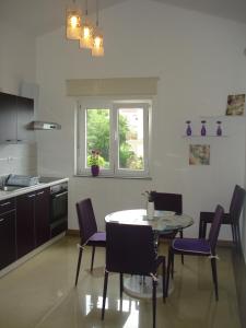 a kitchen with a table and chairs and a window at Apartments Crikvenica in Crikvenica