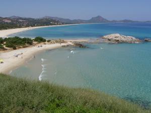 サン・ヴィートにあるCasa vacanze Rose E Fiori Sardegnaの水中の人々の集まりがある海岸