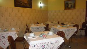 a dining room with three tables with white tablecloths at Residencial Martinho in Lousã