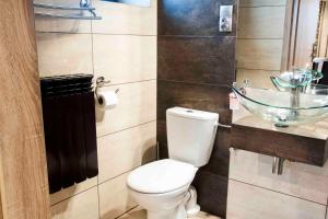 a bathroom with a toilet and a glass sink at Motel Podmiejski in Pleszew