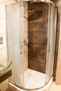 W łazience znajduje się prysznic ze szklanymi drzwiami. w obiekcie Motel Podmiejski w mieście Pleszew