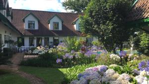 un jardín con flores púrpuras y blancas frente a una casa en Diggersrest Lodge, en Haenertsburg