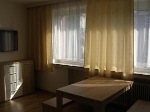 Pokój ze stołem i oknem z zasłonami w obiekcie Apartment Bexor D19 w Hanowerze