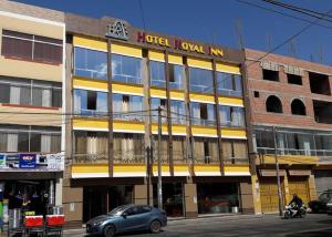 a building with a car parked in front of it at Hotel Royal Inn in Tacna