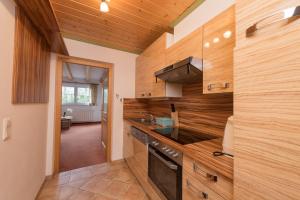 a kitchen with wooden walls and a counter top at Landhaus Charlotte am Geigenbuehel -Apartments in Seefeld in Tirol