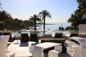 une terrasse avec des chaises et des tables, ainsi qu'une piscine. dans l'établissement Son Caliu Apartamentos, à Palma Nova