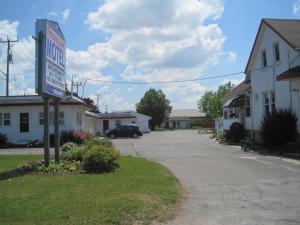 a motel sign in the middle of a parking lot at Rosecourt Motel in Stratford