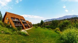 a building on a hill with a green field at San Francisco Lodge & Spa in Los Andes
