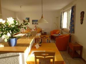 a living room with tables and orange chairs at Haus Abendberg in Wilderswil