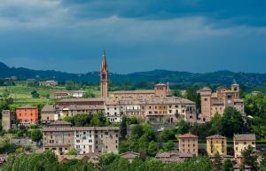 um grupo de edifícios numa colina com uma igreja em B&B il Castello di Vetro em Castelvetro di Modena