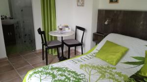 a bedroom with a bed and a table with chairs at Berne &Michel in Montfavet