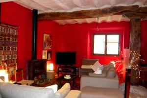 una sala de estar con paredes rojas y muebles blancos. en Casa Rural Usategieta en Genevilla