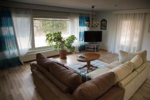 a living room with a large couch and a table at Holiday home in Kuusankoski in Kuusankoski