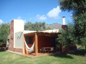 una casa con una hamaca fuera de ella en El Solar De Los Olivos in 