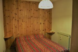 セリーナにあるComodo alloggio a Serinaの木製の壁のベッドルーム1室(ベッド1台付)