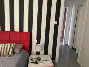 a bedroom with a red bed and a table with a lamp at Casa Meri in Montesilvano