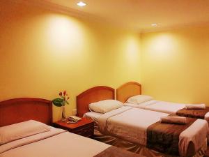 una habitación de hotel con 2 camas en una habitación en SkyGlobal Hotel, en Labuan