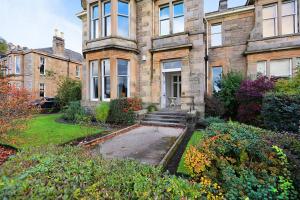 una antigua casa de piedra con un jardín delante de ella en Royal Gardens Apartments en Stirling