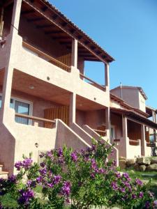 a house with purple flowers in front of it at Complesso Residenziale Marina di Pinarello in Pinarellu