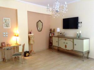 a living room with a tv and a dresser and a mirror at Anthemio in Loutraki