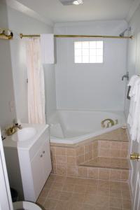 a bathroom with a tub and a sink at Budget Inn in Luray