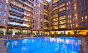 坎帕拉Speke Apartments Wampewo的建筑物中间的一个大型游泳池