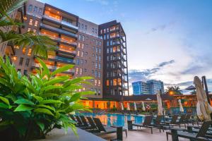 カンパラにあるSpeke Apartments Wampewoの椅子付きのホテル、建物の前のプール