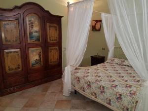 a bedroom with a bed and a wooden cabinet at B&B Verardo in Specchia