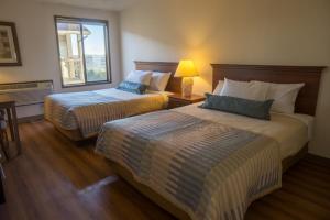 um quarto de hotel com duas camas e uma janela em Sunnyside Inn and Suites em Clackamas