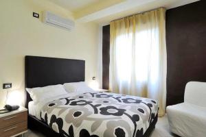 Un dormitorio con una cama en blanco y negro y una ventana en Hotel Le Nereidi en Cervo