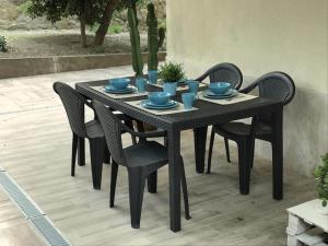 Una mesa negra con sillas y platos azules encima. en semeria103, en San Remo