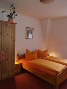 a bedroom with a wooden bed with orange pillows at Gästehaus Loschwitz in Dresden