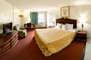 una camera d'albergo con letto e TV di Key West Inn - Newport News a Newport News