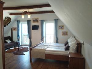 ein Schlafzimmer mit einem Bett, zwei Fenstern und einem Sofa in der Unterkunft Wohlfühlbauernhof Siebernegg in Eibiswald