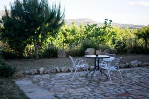une table et des chaises assises sur une terrasse en pierre dans l'établissement Mas Taniet Hotel Rural, à Benissanet