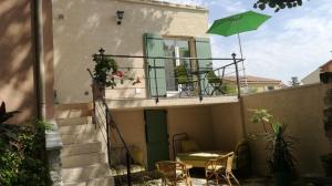 - un balcon avec une table et un parasol vert dans l'établissement Berne &Michel, à Montfavet