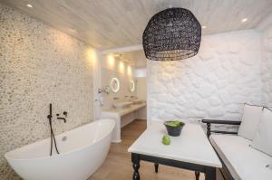 y baño con bañera blanca, lavamanos y bañera. en Cyano Suites en Naxos