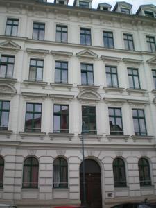 een groot wit gebouw met veel ramen bij Zentrales hochwertiges Gründerzeit-Apartment Thomasius in Leipzig