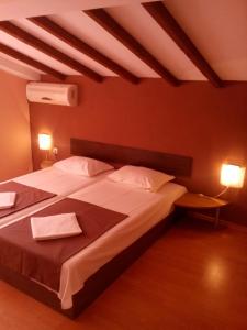 een slaapkamer met een groot bed en 2 handdoeken bij Guest House Hristovi in Aheloy