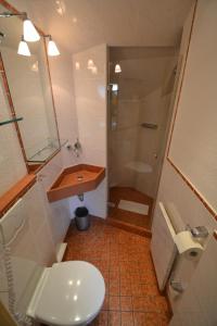 a bathroom with a toilet and a sink and a shower at Priel-Hüs in List