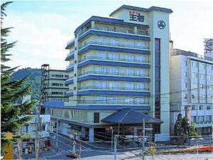 a large building with a clock tower in a city at Hotel Ohsho in Tendo