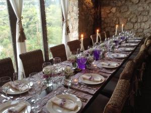 una mesa larga con platos y copas de vino. en Teresa Country Lodge en Eptalofos