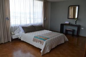 1 dormitorio con cama y ventana grande en Cité, en Quito