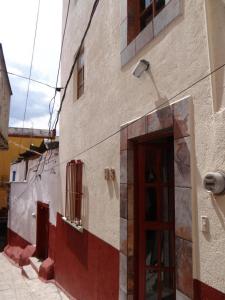 un bâtiment avec une porte rouge sur son côté dans l'établissement Hotel El Beso De Calixto, à Guanajuato