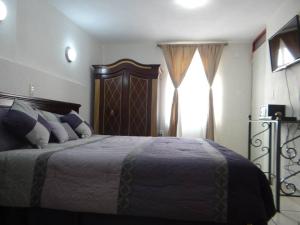 a bedroom with a large bed and a window at Hotel El Beso De Calixto in Guanajuato